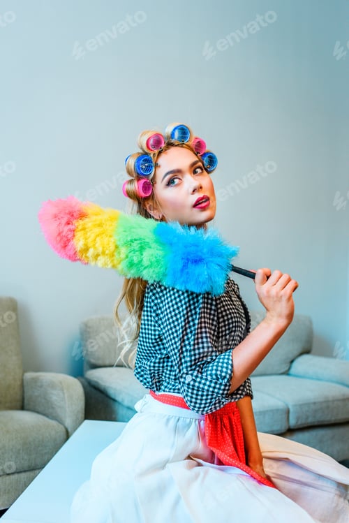 Preview: attractive blonde sensual housewife in curlers cleaning house with duster