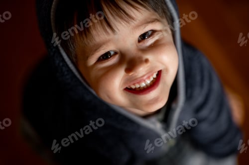 Preview: Portrait of a laughing little boy. Portrait in a dark key