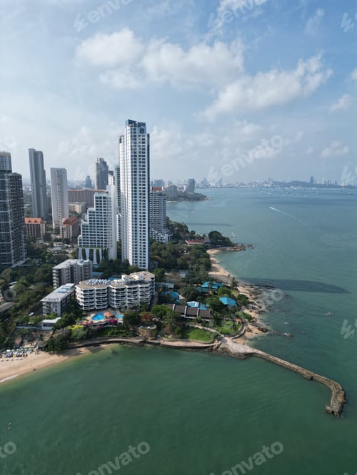 Preview: view of Pattaya city skyline with high-rise buildings along the coastline under a partly cloudy sky.