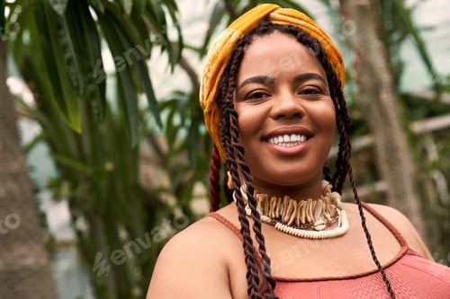 Preview: Joyful moment in a vibrant greenhouse with a stylish African American woman