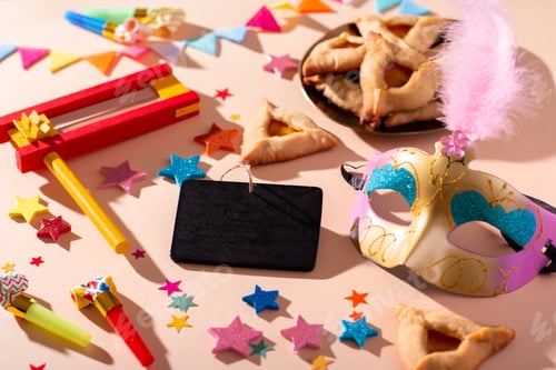 Preview: Purim table with hamantaschen cookies, carnival mask, black board for text, holiday decor in hard li