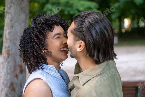 Preview: Interracial couple laughing in park enjoying happy moment