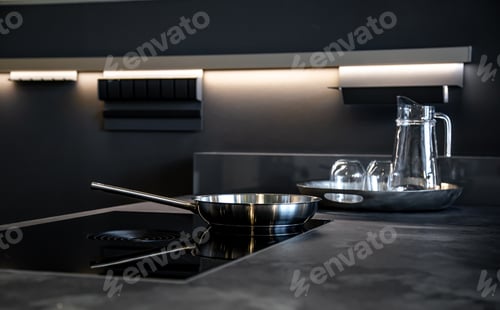 Preview: Frying pan in the interior of the kitchen in black, modern style.