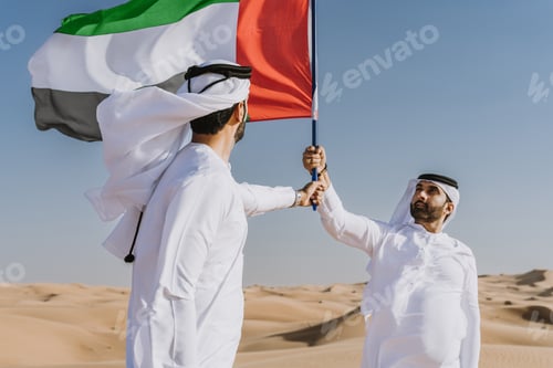 Preview: Two middle-eastern emirati men wearing arab kandura bonding in the desert