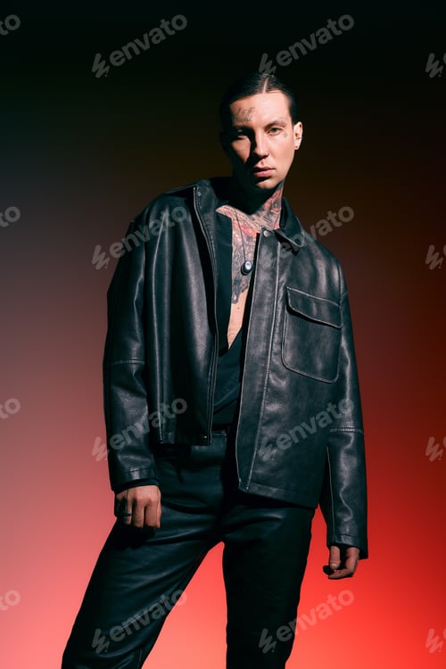 Preview: Stylish young man poses confidently in a chic leather outfit against a dramatic backdrop