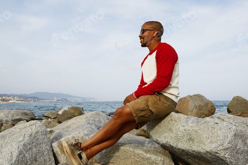 Preview: Smiling young African-American hipster enjoing summer day on the beach outside of the city.