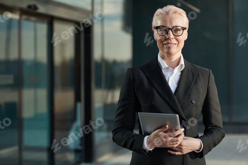 Preview: Businesswoman with tablet pc outdoors