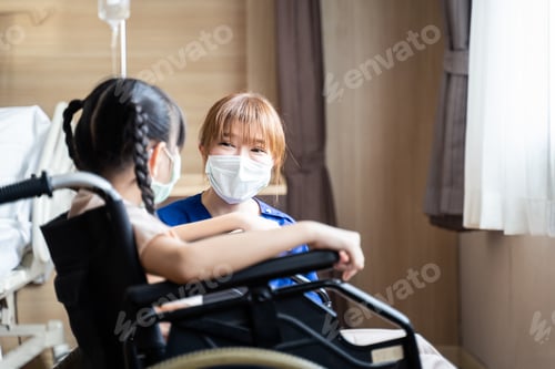Preview: Asian nurse serves medical care service to young kid patient on wheelchair in recovery room.