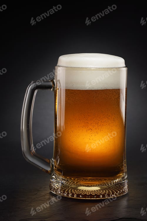 Preview: Mug with fresh beer with cap of foam on a black.