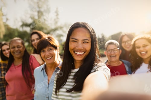 Preview: Happy multigenerational group of women having fun taking selfie with smartphone camera in a park