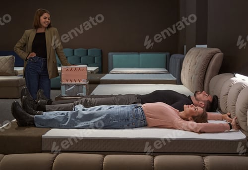 Preview: Woman and man trying out mattress before buying