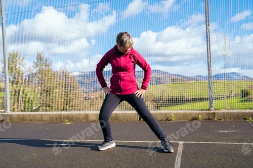 Preview: Woman doing side lunge stretching outdoors for fitness