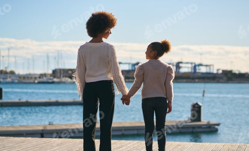 Preview: A woman and a child are standing on a dock by the water