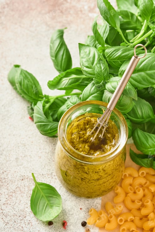 Preview: Jar with homemade pesto sauce on rustic background with parmesan cheese, olive oil, sause pesto, bas
