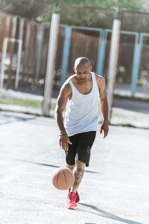 Preview: african american basketball player training on court alone