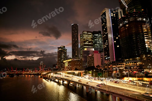 Preview: City skyline at dusk with illuminated buildings and busy traffic