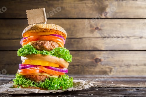 Preview: Double-decker burger on wooden background with space to menu