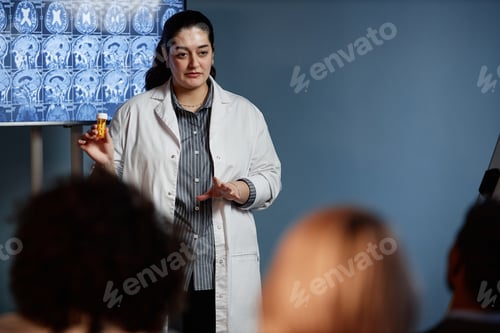Vista previa: Doctora mostrando píldoras durante una presentación en una conferencia de neurología