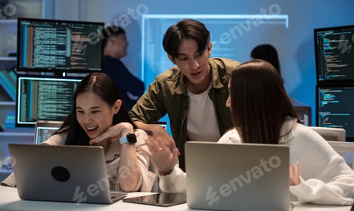 Preview: Young Asian business team working late on coding and brainstorming ideas