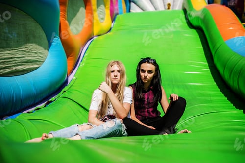 Preview: Gorgeous girls having fun on a slide on a sunny day.