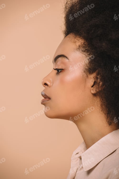 Preview: side view of attractive african american woman isolated on beige