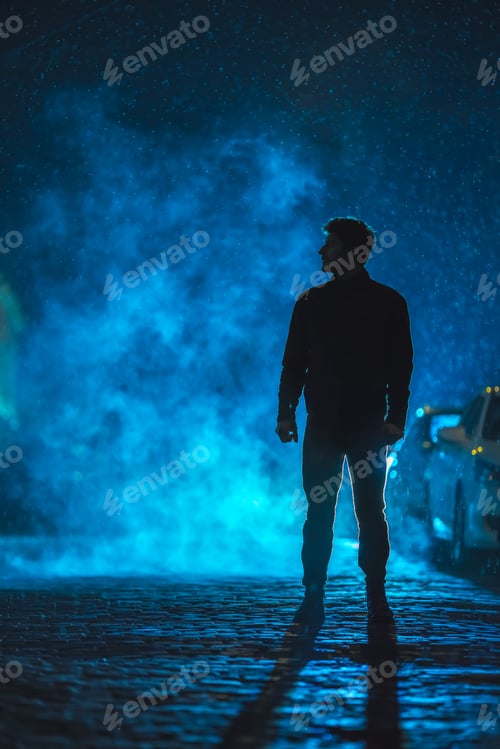 Preview: The man stand on the smoky street. Evening night time. Telephoto lens shot.