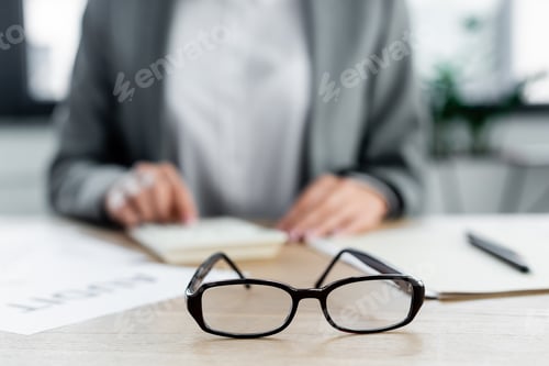 Preview: selective focus of glasses near chief financial officer in office