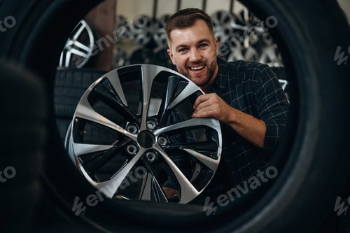 Preview: Brand new disk. Man worker is maintenance station with tires, wheels
