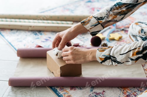 Preview: Woman hands packing Christmas gift at home