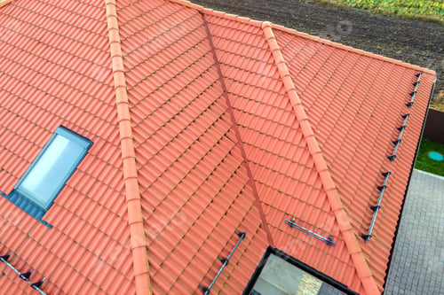 Preview: Closeup of house brick roof with yellow shingles cover and attic glass windows