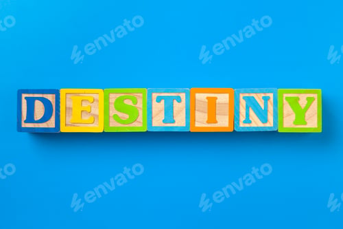 Preview: Destiny. Wooden colorful alphabet blocks on blue background, flat lay, top view