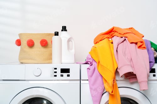 Preview: White Washing Machines With Colorful Clothes in a Laundry Room