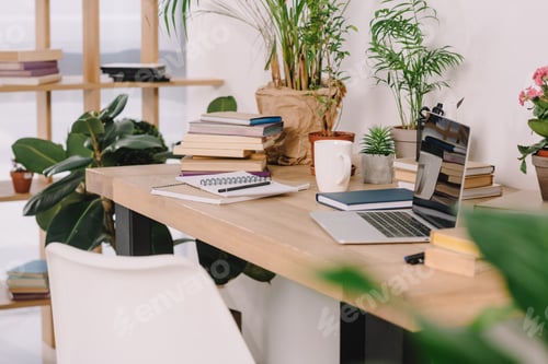 Preview: laptop on wooden table with potted plants in workspace