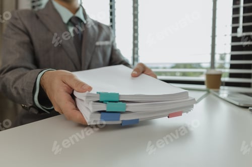 Preview: An office worker is putting important documents together to keep everything safe. A businessman is p