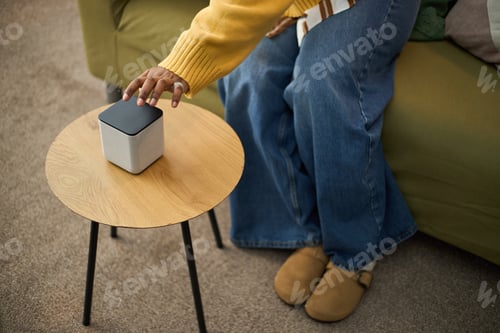 Preview: Hand Using Modern Gadget on Wooden Side Table in Living Room