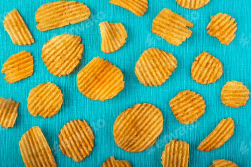 Preview: Potato chips, grooved gold chips, corrugated crispy snacks on a turquoise background