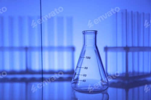 Preview: Empty flask on mirror surface against blue background. Laboratory equipment