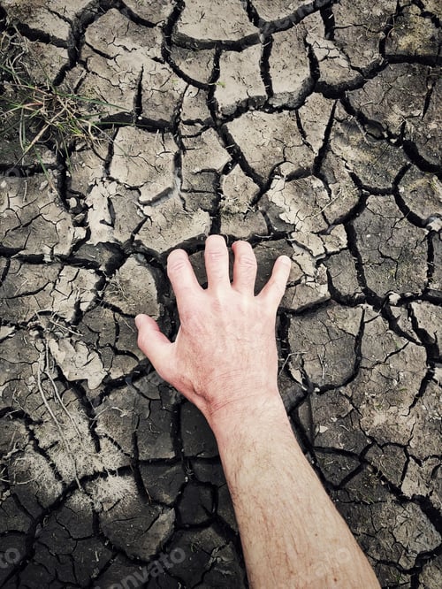 Preview: desperate human hand clawing and scraping dry and cracked earth in a drought environmental concept