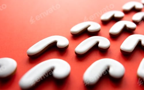 Preview: A lot of gingerbread candy cane shaped cookies on a red background.