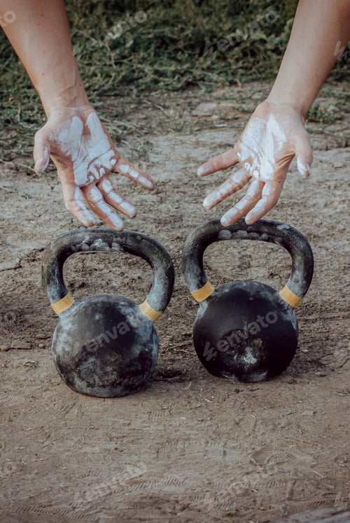 Preview: Hands in powdered magnesia and kettlebells for functional training.