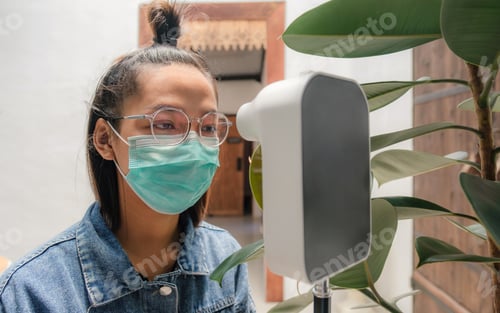 Preview: The Asian tourist woman has checked body temperature with a thermal Temperature scanner detector