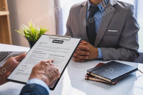 Preview: An employer interviewing for a job or head of HR is reading a resume while discussing the resume. An
