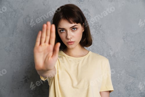 Preview: Angry serious young woman showing stop gesture