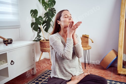 Preview: Woman Meditating Indoors at Home in Peaceful Setting