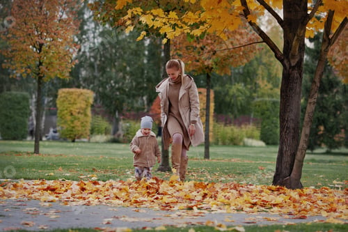 Preview: Candid Family run through fall yellow leaves. Mother and child laughing and having fun in nature