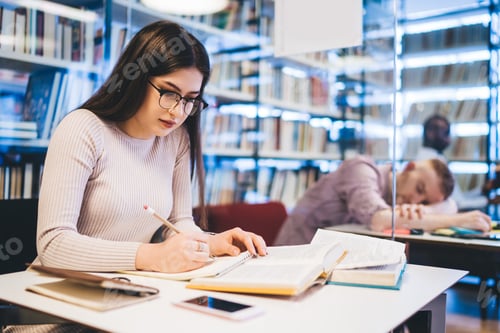 Preview: Focused female student studying in library