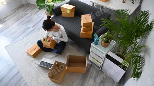 Preview: Overhead view young start up small business entrepreneur preparing parcel boxes.
