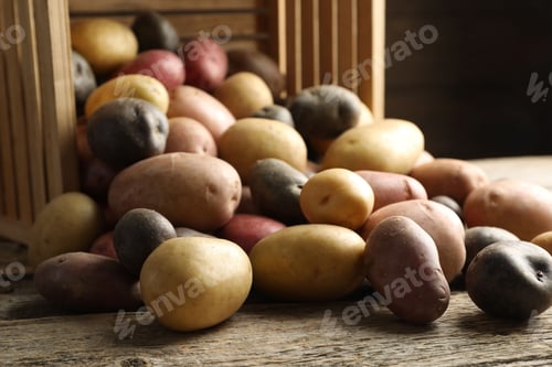 Preview: Different types of potatoes on wooden table, closeup