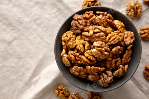 Preview: Raw Walnut Halfs in a Bowl, top view. Flat lay, overhead. Copy space.