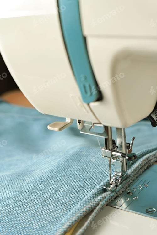 Preview: sewing machine with special presser foot makes a seam on grey leather. sewing process close up
